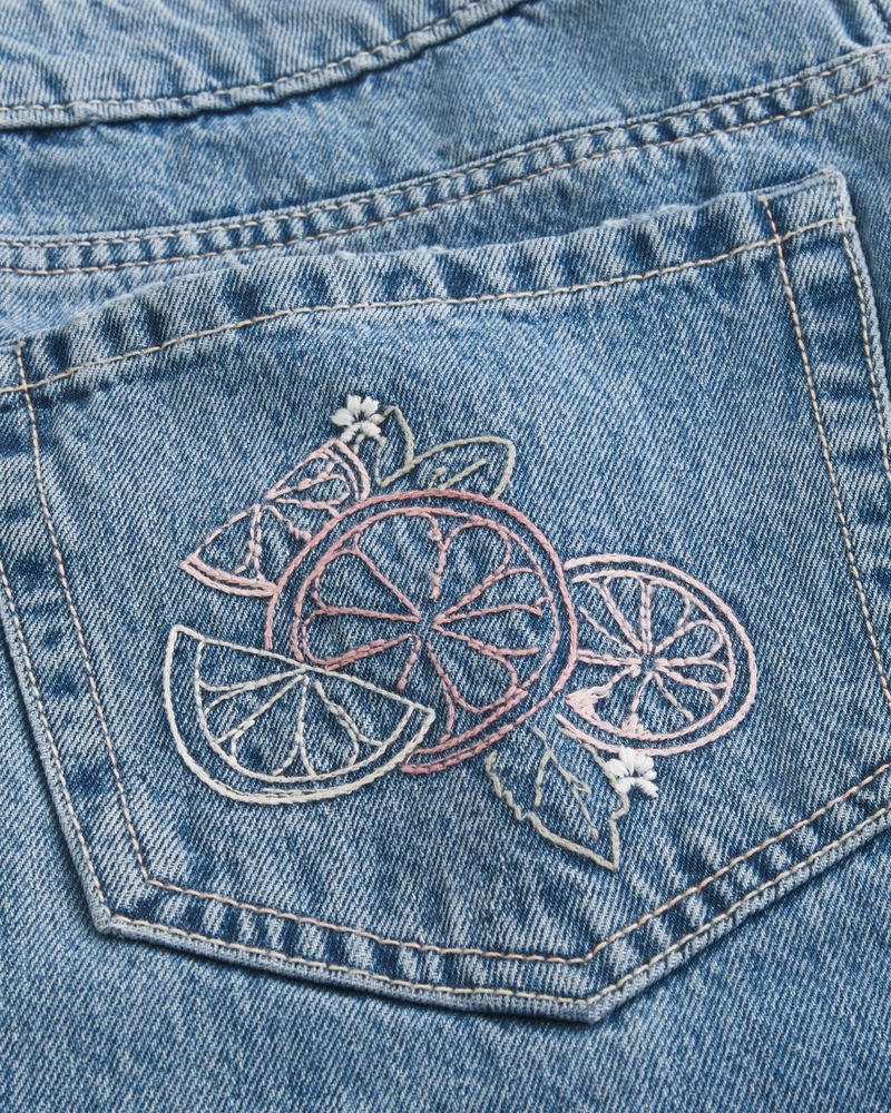hüftig geschnittene mittelblaue jeans mit gestickten früchten und lockerer passform